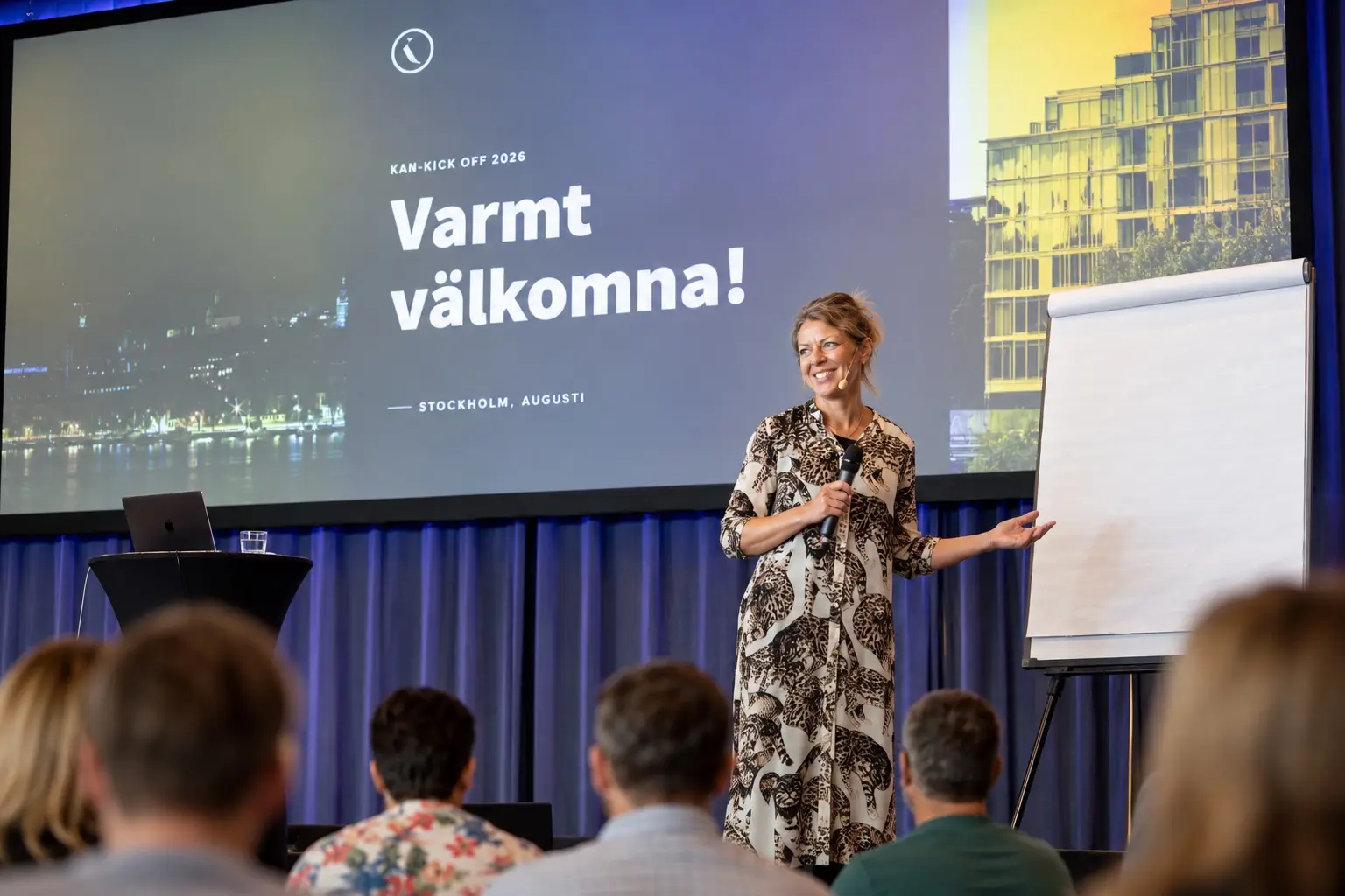 Moderator med mikrofon i samtal på en scen